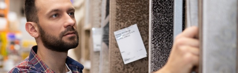 Picture of man choosing carpeted flooring in a retail store