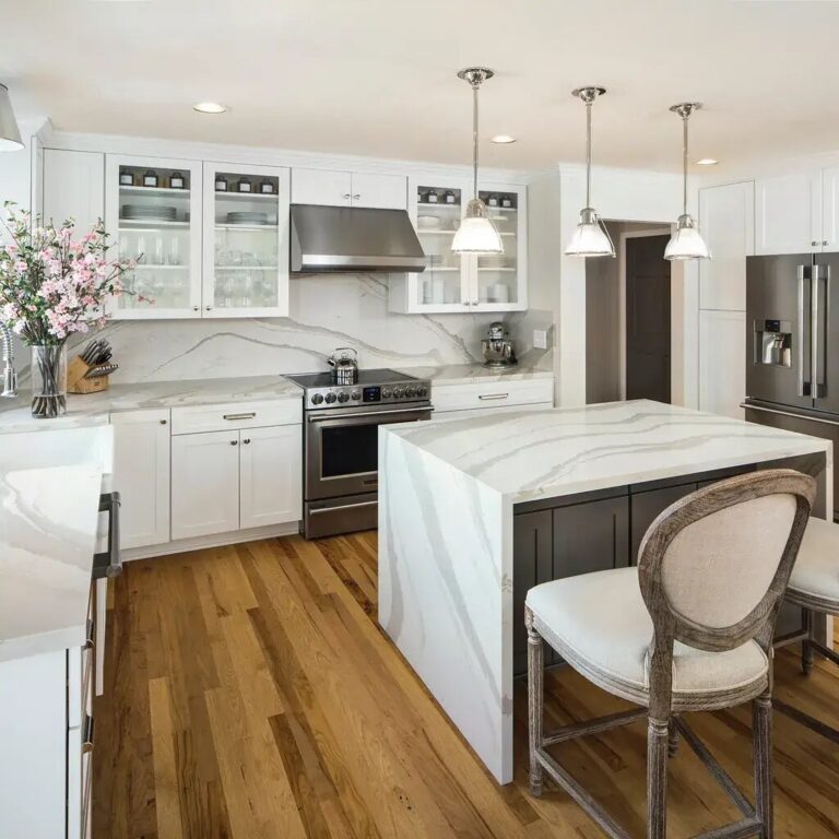 old oak flooring in a transitional kitchen with waterfall edge island counter in granite