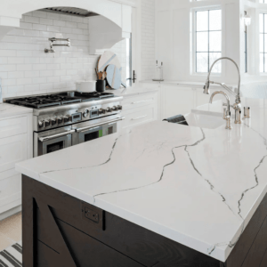 a kitchen with a white and black solid surface island and large gas range