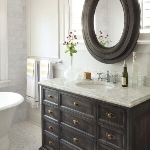 Modern farmhouse bathroom with dark vanity and matching round mirror