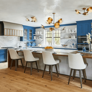 Country kitchen with bright blue cabetry and combination white solid surface counter with wood bar attached